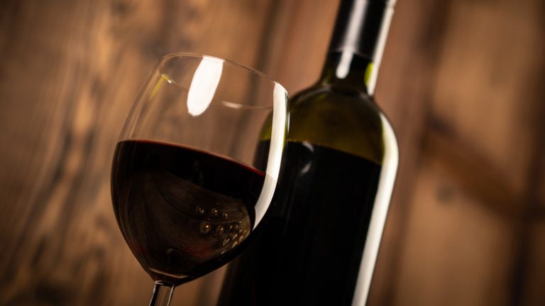 dark cabernet sauvignon wine glass and mystery bottle